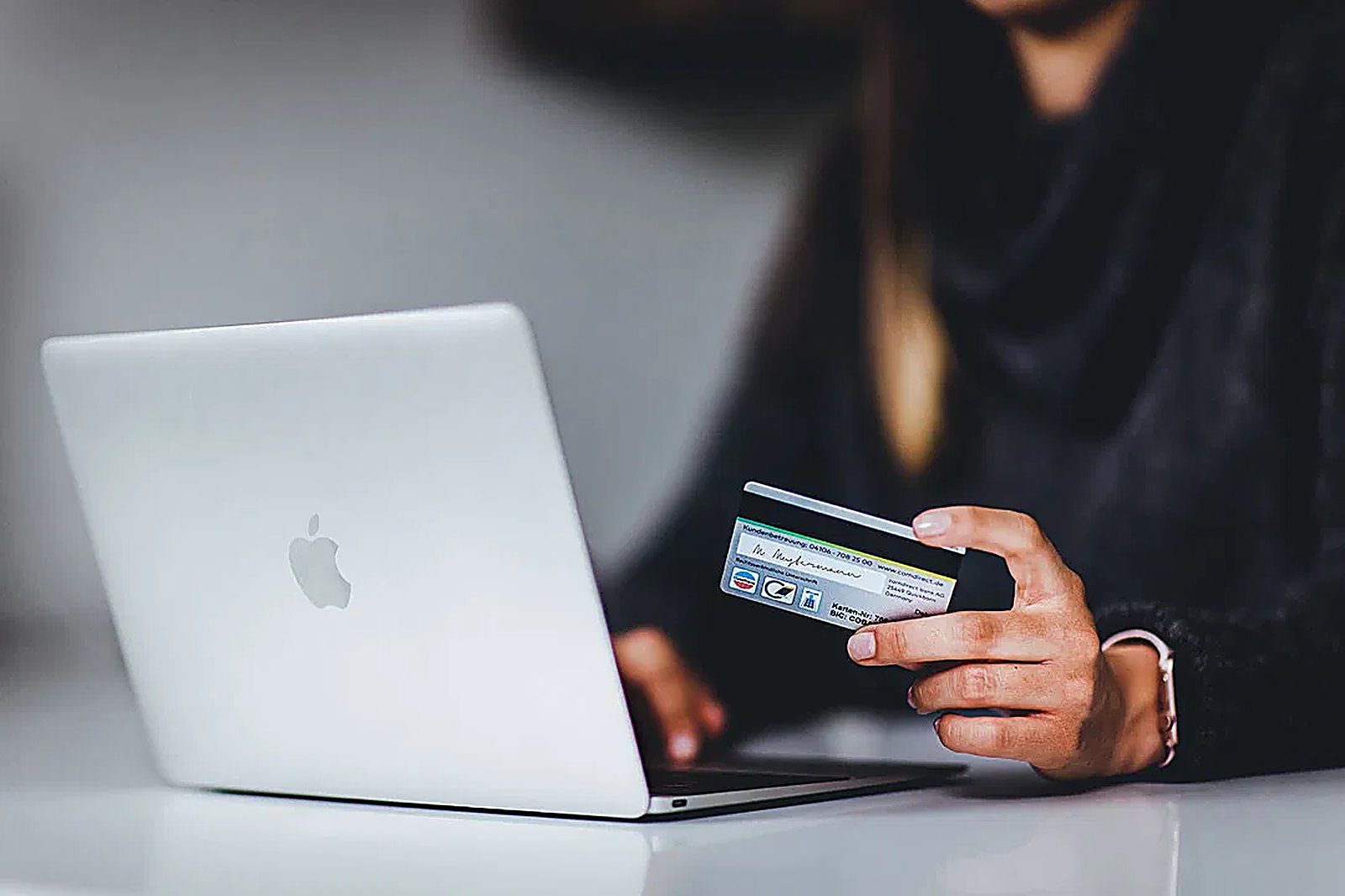 A person entering card details on a laptop