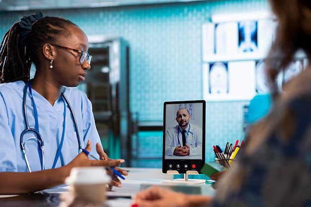 A nurse consulting a physician over a tablet video call